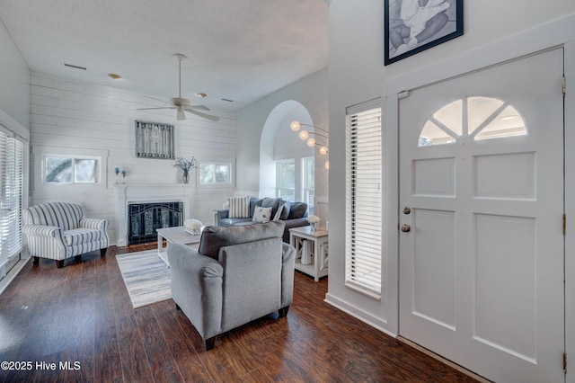 living room featuring dark wood-type flooring and ceiling fan