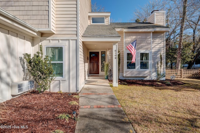 view of exterior entry with a yard