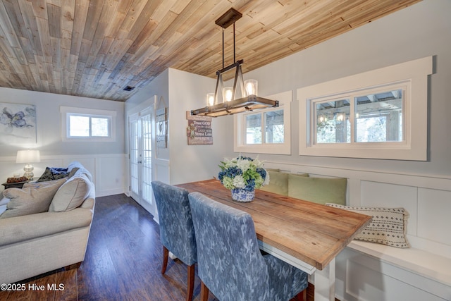 dining space with dark wood-type flooring, wood ceiling, and french doors