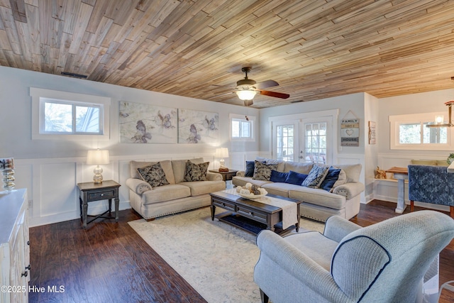 living room featuring dark hardwood / wood-style flooring, ceiling fan with notable chandelier, wooden ceiling, and french doors