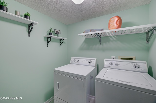 washroom with washer and dryer and a textured ceiling