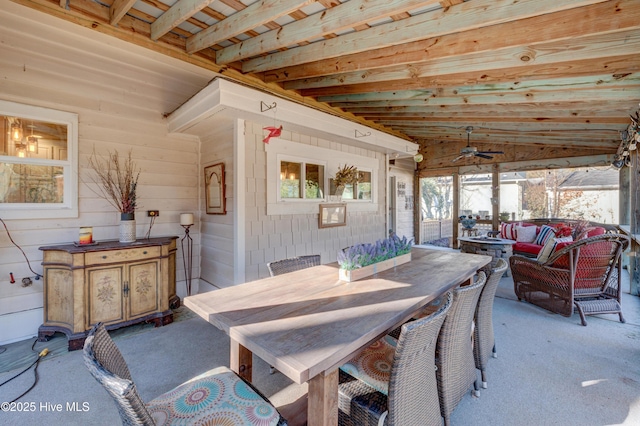 carpeted dining space featuring ceiling fan and wood walls