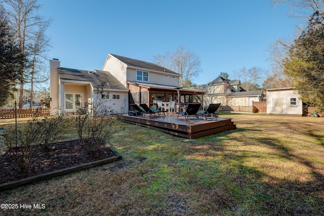 back of house featuring a wooden deck, a lawn, and a storage unit