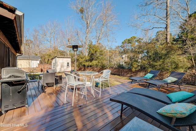 deck featuring area for grilling and a storage unit