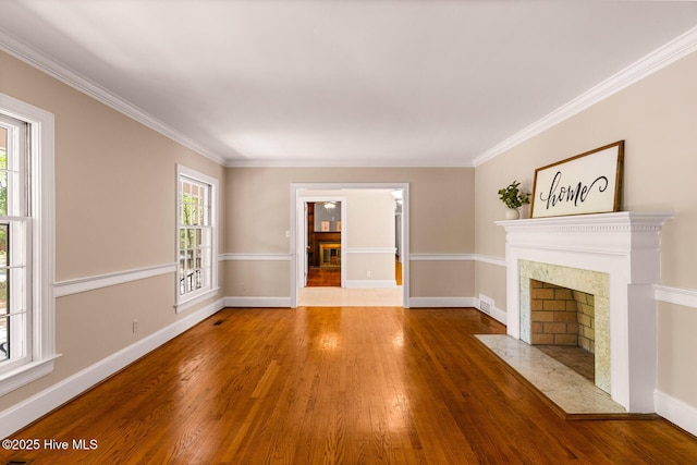 unfurnished living room featuring hardwood / wood-style flooring and crown molding