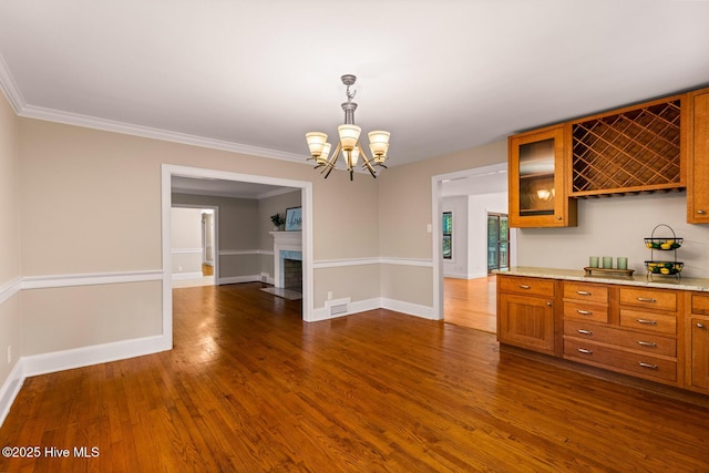 kitchen with ornamental molding, dark wood-type flooring, and pendant lighting