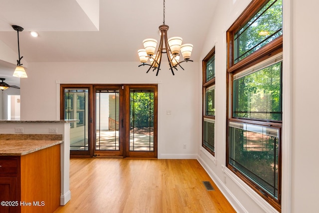 interior space featuring a chandelier, a healthy amount of sunlight, and light wood-type flooring