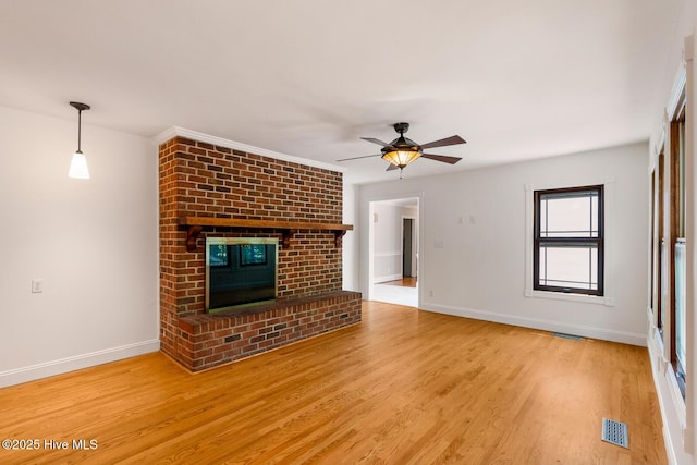 unfurnished living room with ceiling fan, hardwood / wood-style floors, and a fireplace