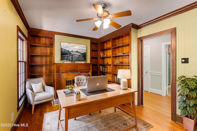 office area featuring ornamental molding, built in features, ceiling fan, and light hardwood / wood-style floors