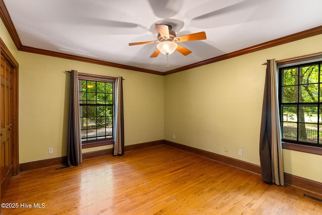 unfurnished room featuring ornamental molding, plenty of natural light, ceiling fan, and light hardwood / wood-style flooring