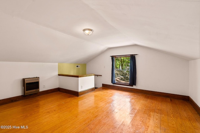 bonus room with heating unit, hardwood / wood-style flooring, and lofted ceiling