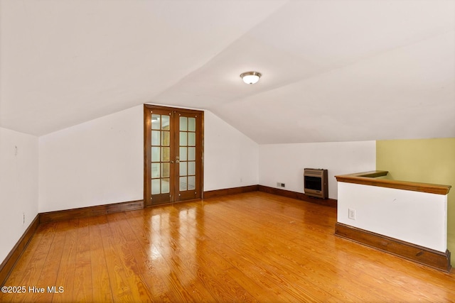 additional living space featuring french doors, wood-type flooring, and vaulted ceiling