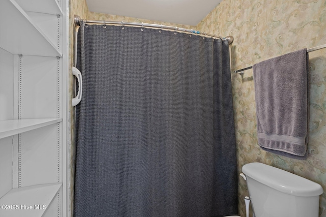 bathroom with a shower with shower curtain and toilet