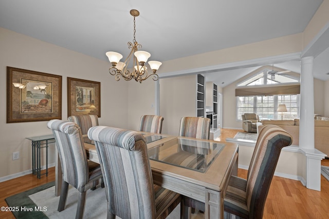 dining area featuring decorative columns, lofted ceiling, a notable chandelier, and light wood-type flooring