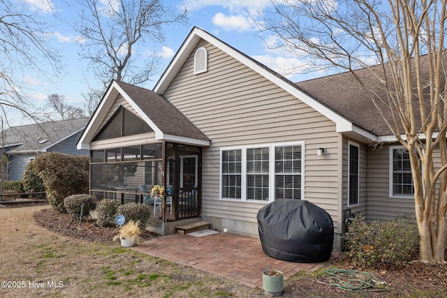 back of property with a patio area and a sunroom