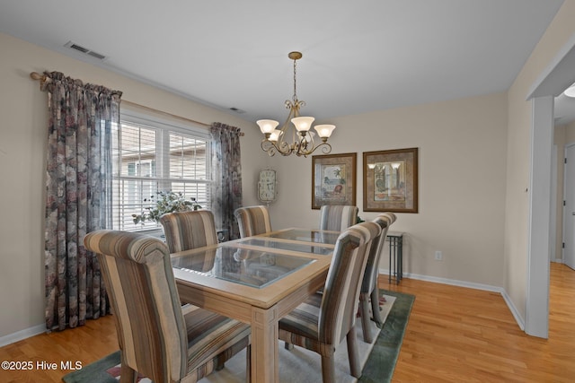 dining room featuring light hardwood / wood-style floors and a chandelier