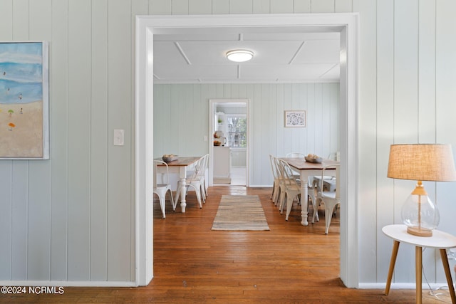 hallway featuring wooden walls and hardwood / wood-style floors