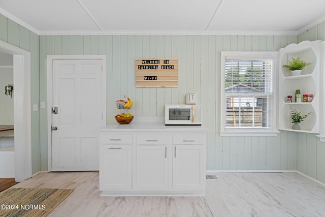 kitchen with ornamental molding and white cabinets