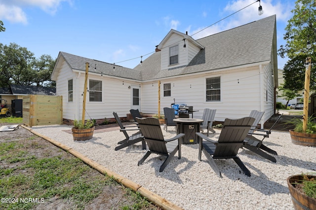 rear view of property with an outdoor fire pit