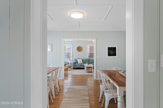 hall with hardwood / wood-style flooring and wooden walls