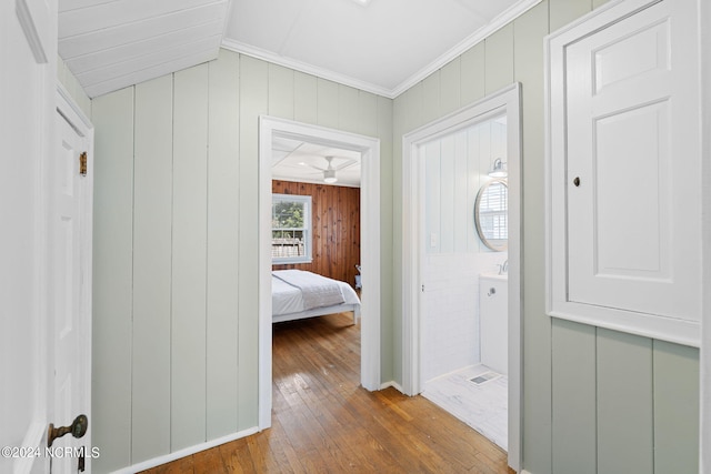 corridor with hardwood / wood-style floors and ornamental molding