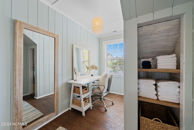 home office with crown molding, dark wood-type flooring, and wood walls