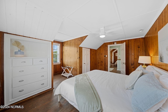 bedroom with dark hardwood / wood-style flooring, ensuite bath, ceiling fan, and wood walls