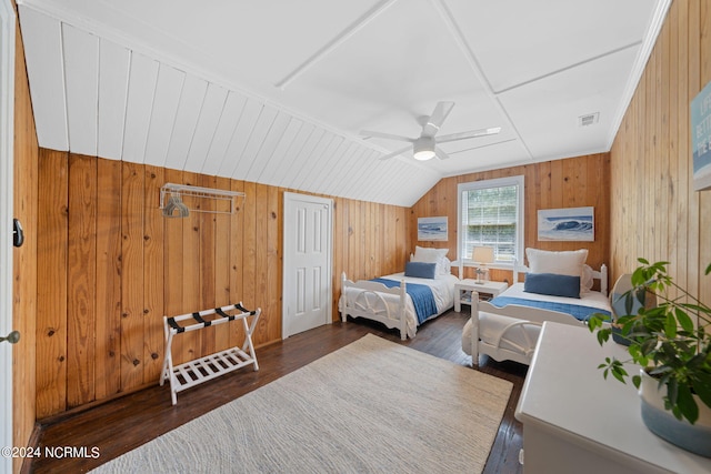 bedroom with dark wood-type flooring, wooden walls, and ceiling fan