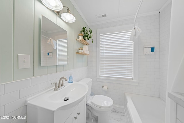 bathroom featuring a healthy amount of sunlight, vanity, toilet, and tile walls