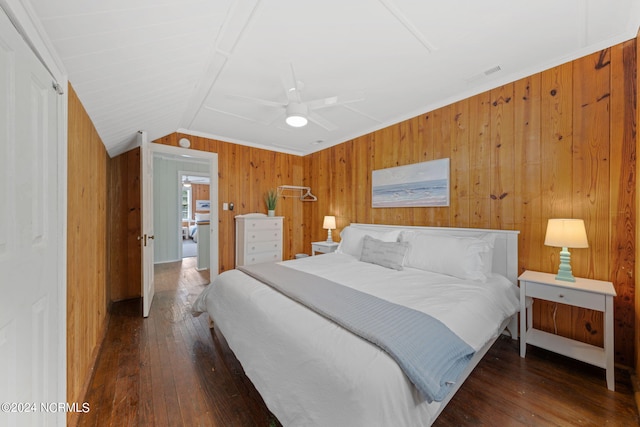 bedroom featuring dark hardwood / wood-style floors, wood walls, lofted ceiling, ceiling fan, and crown molding