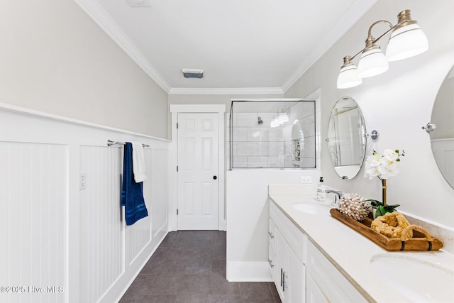 bathroom with crown molding, a tile shower, and vanity