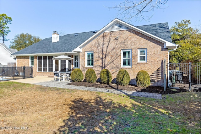 rear view of property with a yard and a patio area