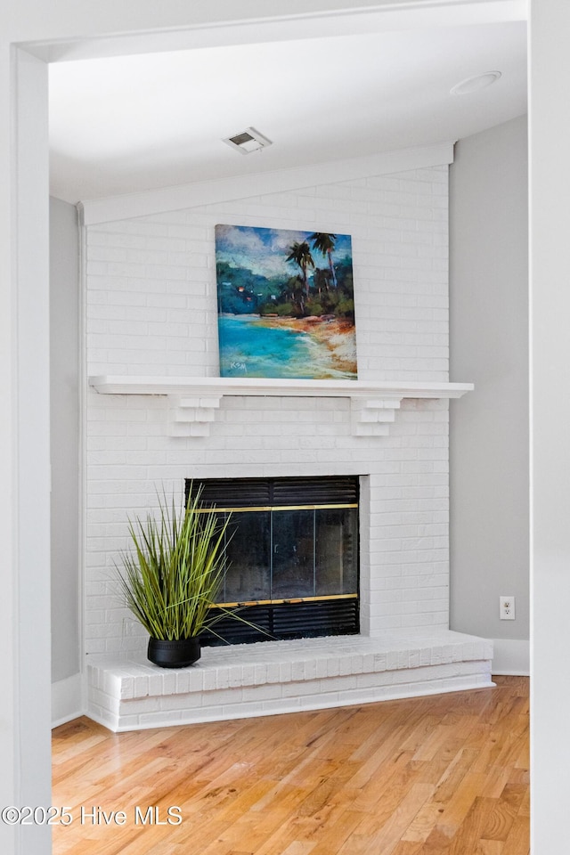 interior details with wood-type flooring and a fireplace