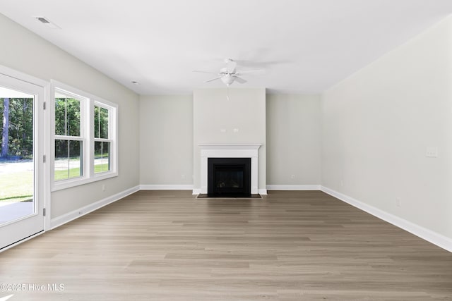 unfurnished living room with ceiling fan and light hardwood / wood-style floors