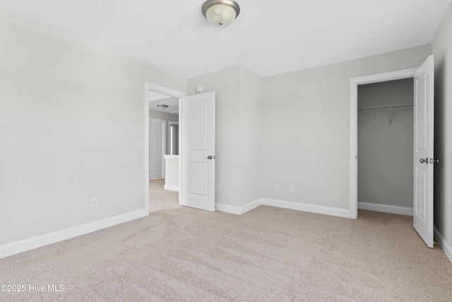 unfurnished bedroom with light colored carpet and a closet