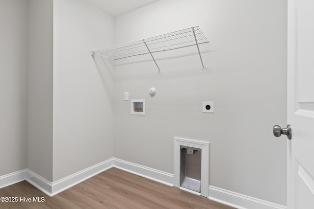 clothes washing area featuring washer hookup, hookup for a gas dryer, electric dryer hookup, and hardwood / wood-style flooring