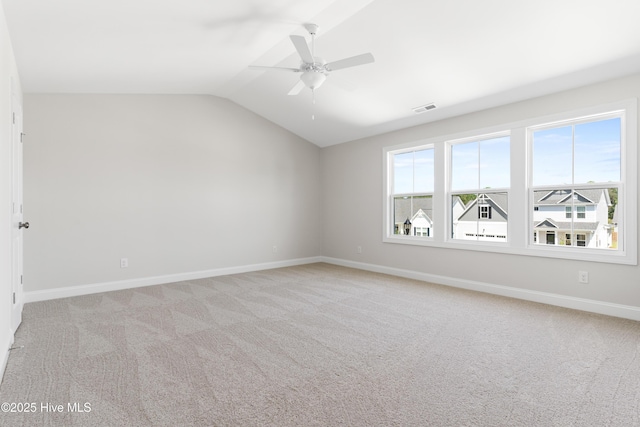 spare room featuring lofted ceiling, light carpet, and ceiling fan