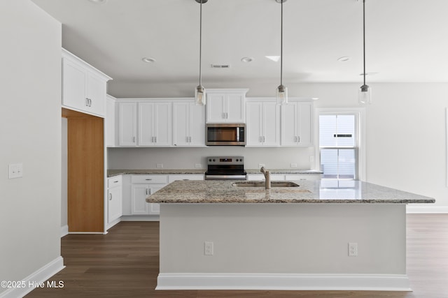 kitchen with an island with sink, appliances with stainless steel finishes, and pendant lighting