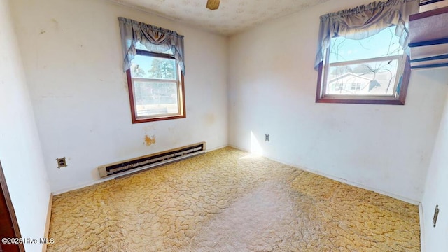 carpeted empty room featuring a baseboard radiator, a textured ceiling, and ceiling fan