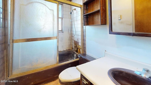 full bathroom featuring enclosed tub / shower combo, vanity, and toilet