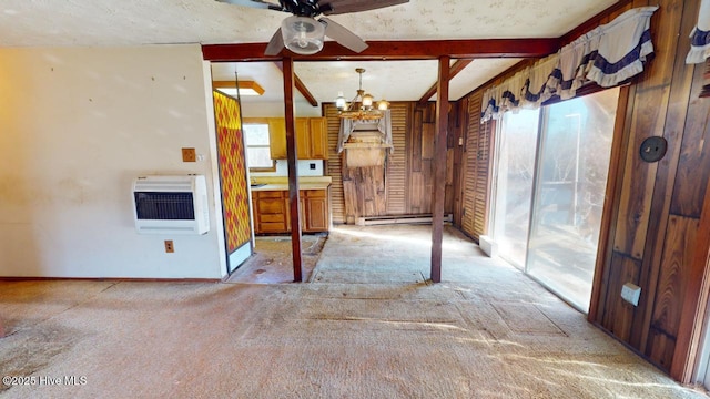 carpeted spare room with beamed ceiling, a baseboard radiator, a healthy amount of sunlight, and heating unit