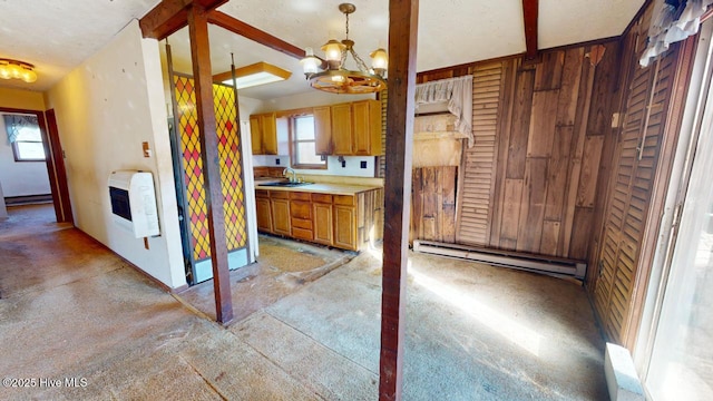 kitchen featuring heating unit, pendant lighting, sink, a baseboard heating unit, and an inviting chandelier