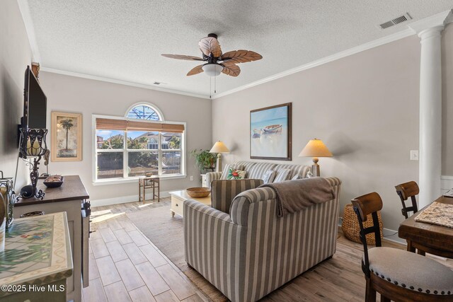 living room with ornamental molding, a textured ceiling, and light wood-type flooring