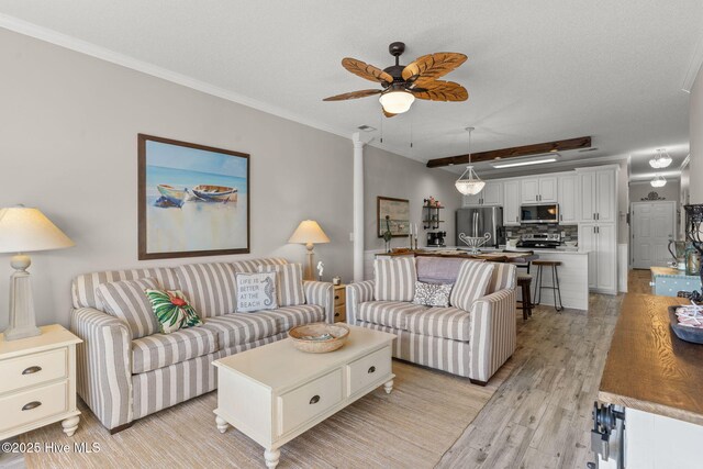 living room with crown molding, ceiling fan, and light wood-type flooring