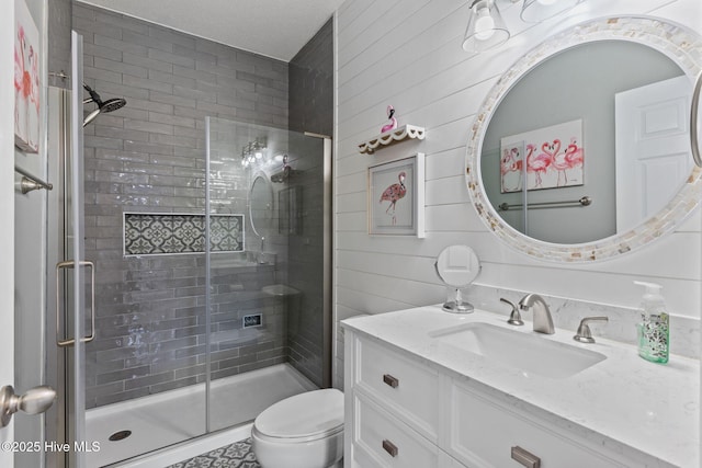 bathroom featuring vanity, an enclosed shower, wooden walls, and toilet