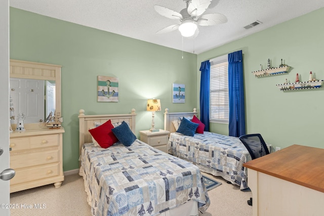 carpeted bedroom featuring ceiling fan and a textured ceiling