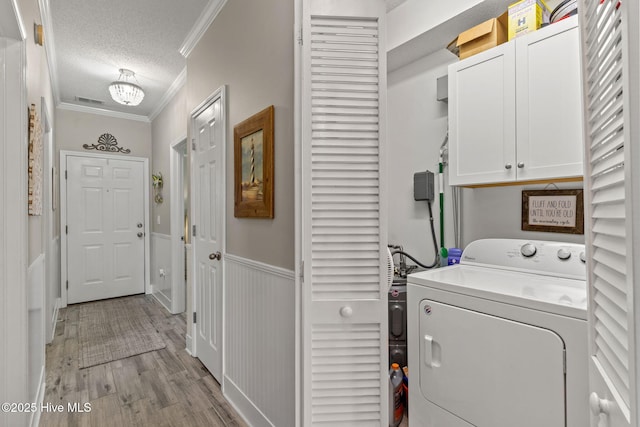 laundry area with washer / dryer, cabinets, ornamental molding, light hardwood / wood-style floors, and a textured ceiling