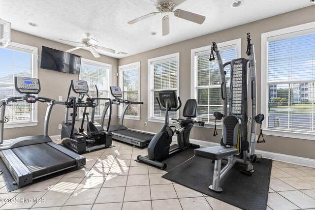 workout area with light tile patterned floors, a textured ceiling, a healthy amount of sunlight, and ceiling fan