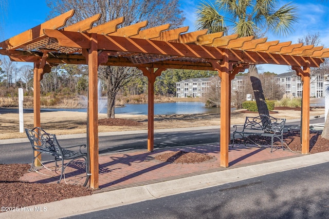 view of home's community with a water view and a pergola