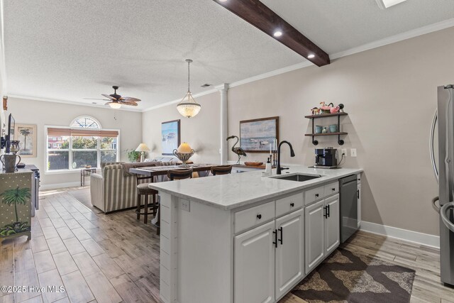 kitchen with white cabinetry, crown molding, hanging light fixtures, light hardwood / wood-style flooring, and stainless steel appliances